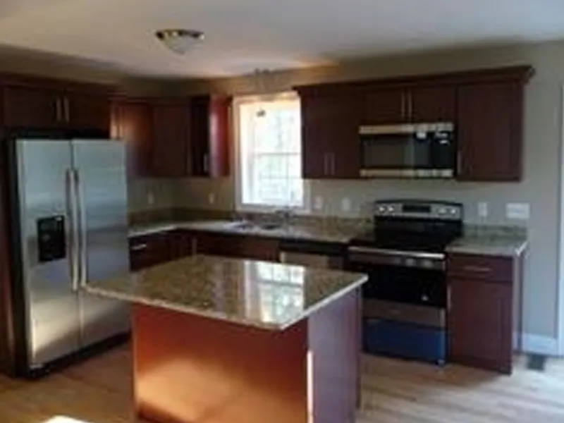 Modern kitchen with granite countertops, stainless steel appliances, and wood cabinets.