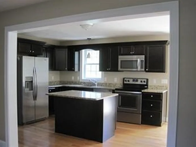 Modern kitchen with dark cabinets, stainless steel appliances, and a central island.
