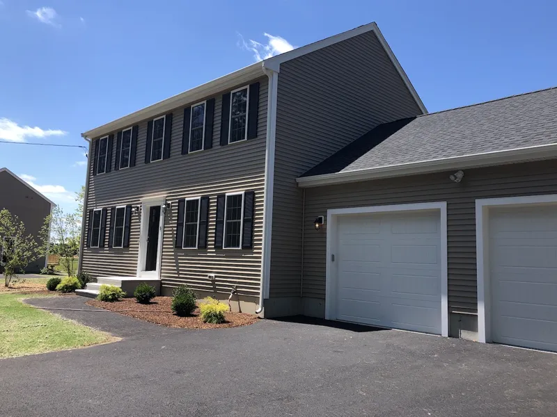 Two-story gray house with white trim, black shutters, and a two-car garage.