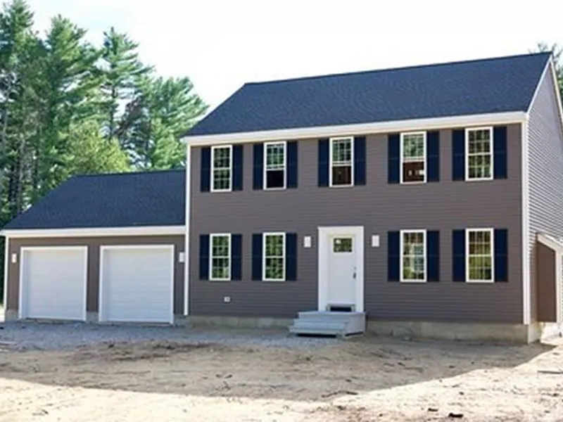 Two-story house with gray siding, black shutters, and a two-car garage, outdoors.