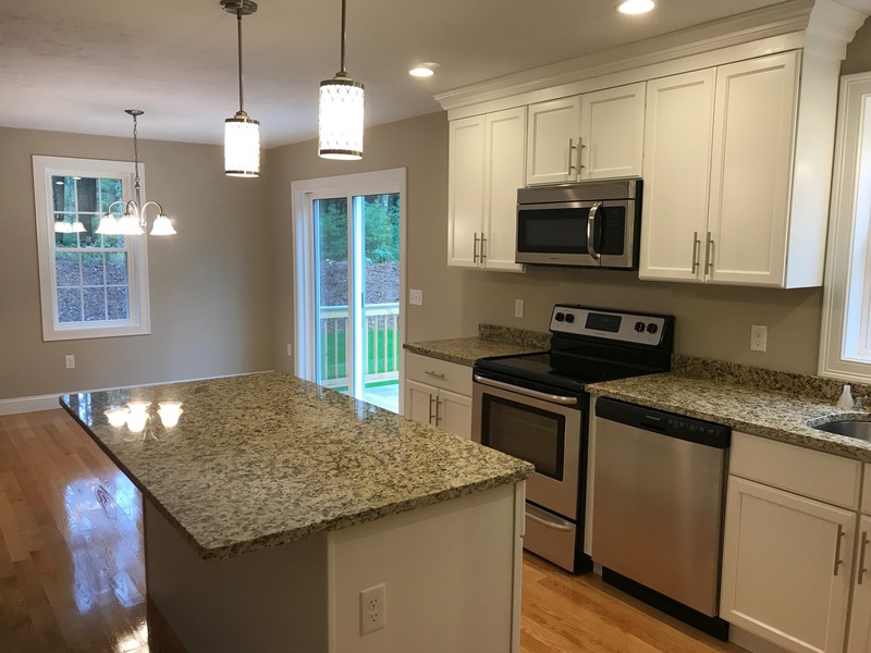 Modern kitchen with granite countertops, stainless steel appliances, and white cabinets.