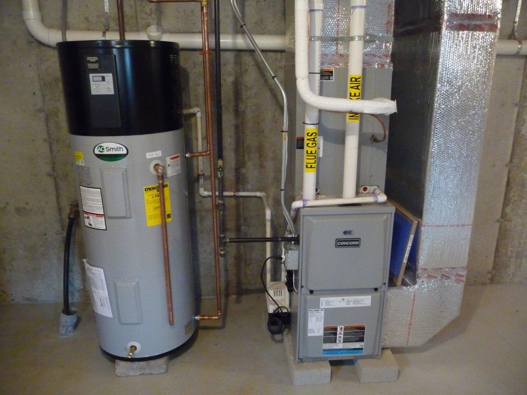 Water heater and furnace with ventilation pipes in a basement utility area.