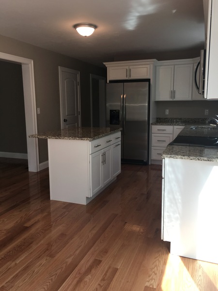Modern kitchen with white cabinets, granite countertops, and stainless steel appliances.