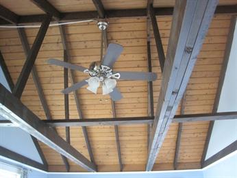Ceiling fan mounted on a wooden, exposed-beam ceiling.