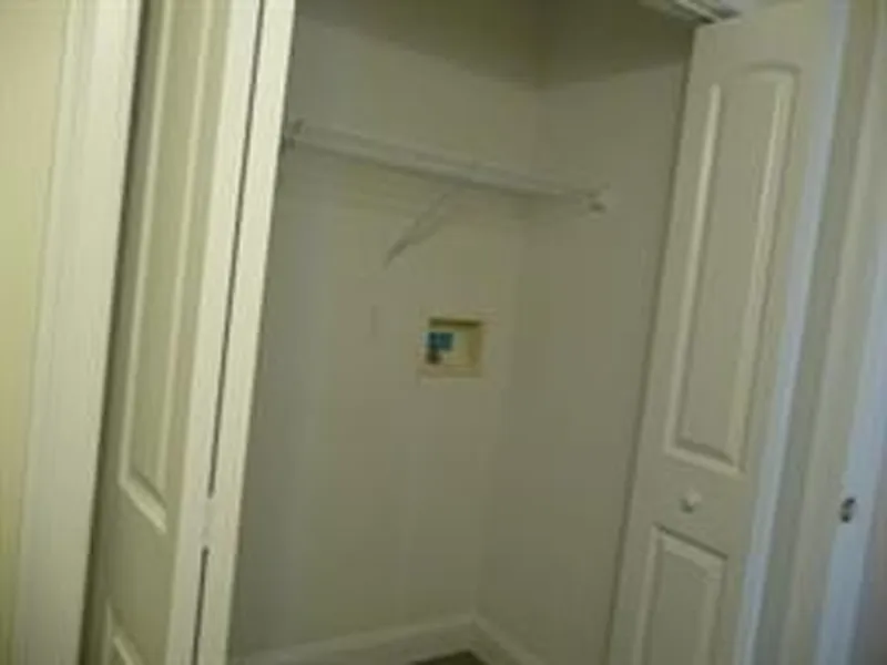 Empty closet with bifold doors, shelf, and a recessed utility box on the back wall.