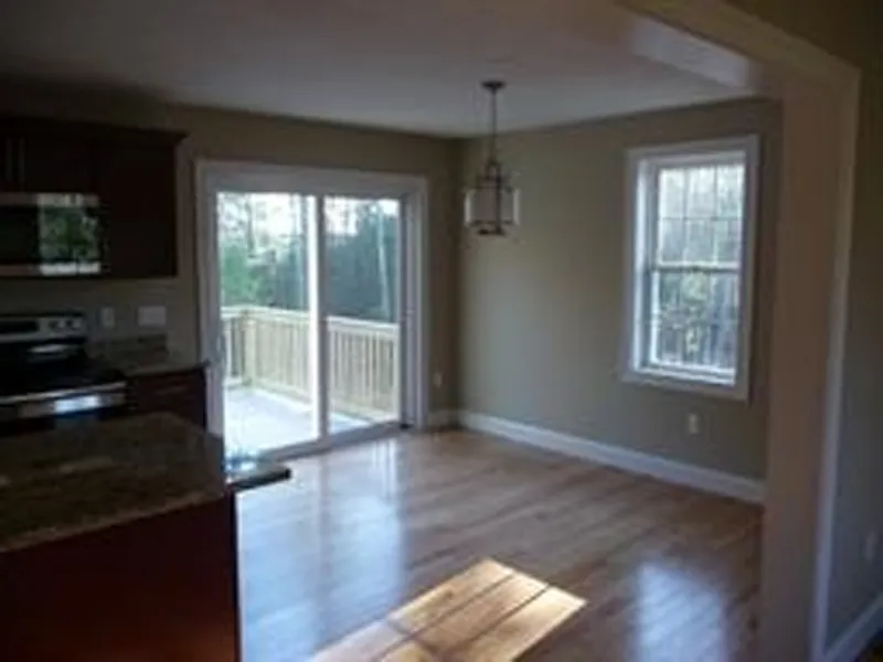 Bright kitchen with wood floors, granite counters, and sliding doors to a deck.