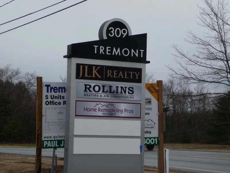 Outdoor business sign for 309 Tremont with multiple company names listed on it.
