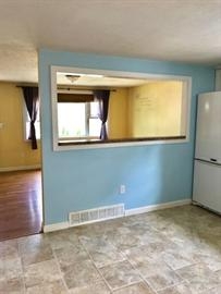 Kitchen with blue walls, tile floor, and a large pass-through window to the dining room.