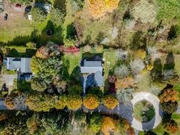 Aerial view of houses, trees, and a circular driveway in a suburban neighborhood.