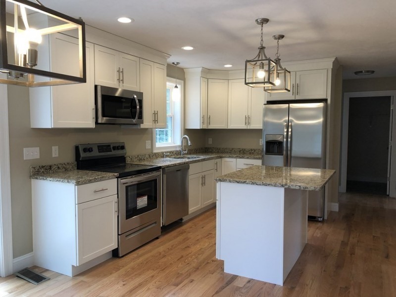 Modern kitchen with white cabinets, stainless steel appliances, and granite countertops.