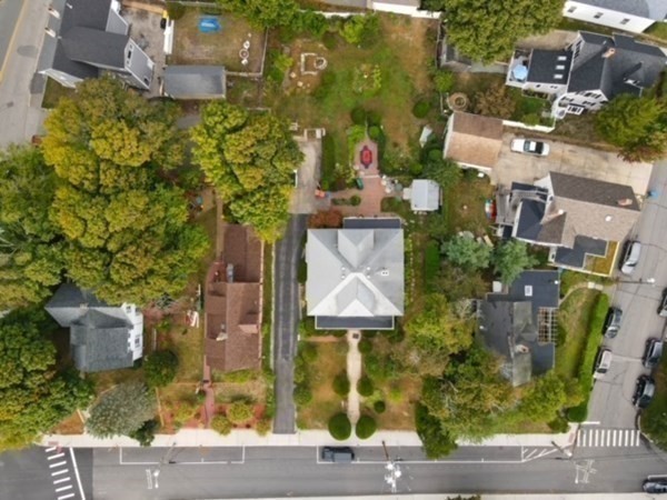 Aerial view of houses, roads, and trees in a residential neighborhood.