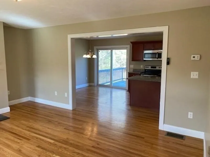 Open living space with hardwood floors, kitchen, dining area, and sliding glass doors.
