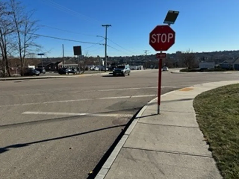 A stop sign stands beside a suburban street on a sunny, clear day.