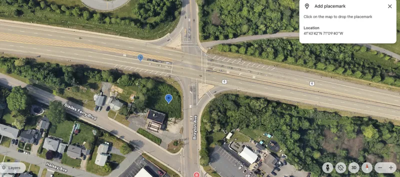 Aerial view of a large road intersection surrounded by trees and several buildings.