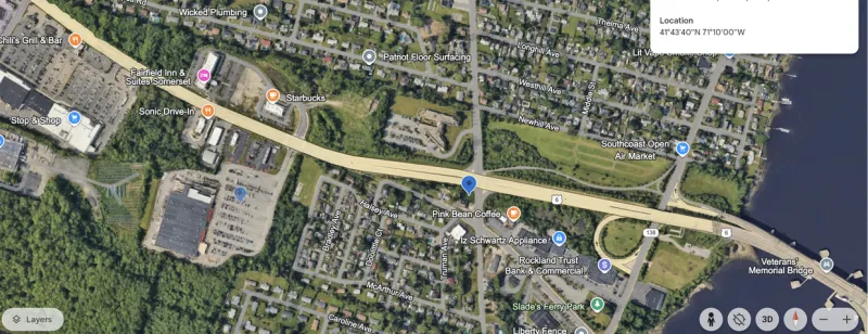 A satellite map showing a highway, river, and several businesses and houses in a town.
