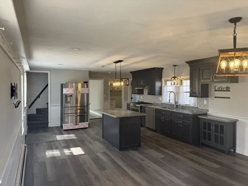 Modern kitchen with dark cabinets, stainless steel appliances, and a center island.