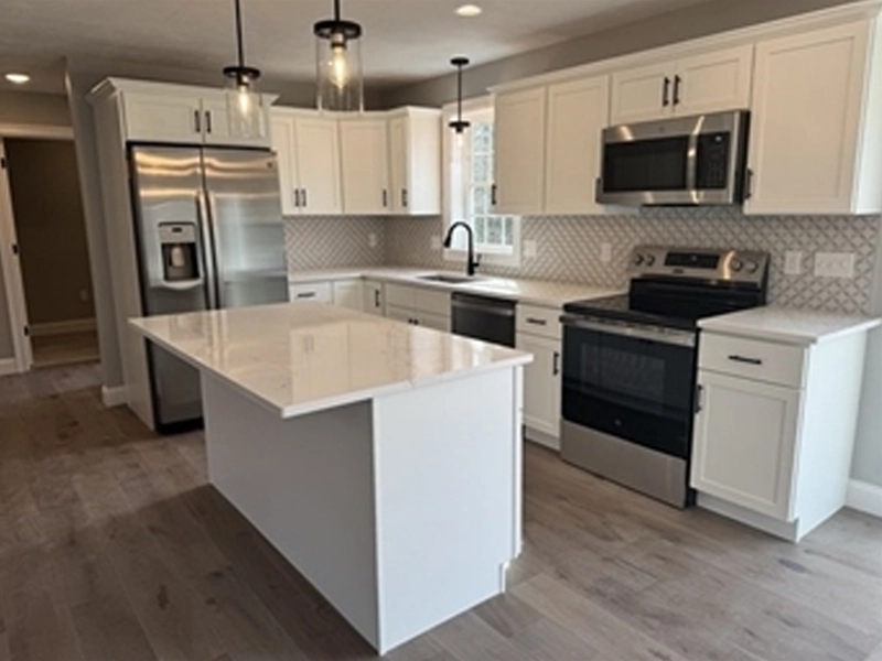 Modern kitchen with white cabinets, stainless steel appliances, and a central island.