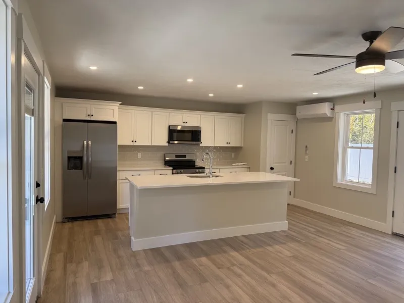 Modern kitchen with white cabinets, stainless steel appliances, and a center island.