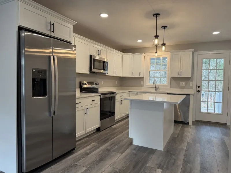 Modern kitchen with white cabinets, stainless steel appliances, and a center island.